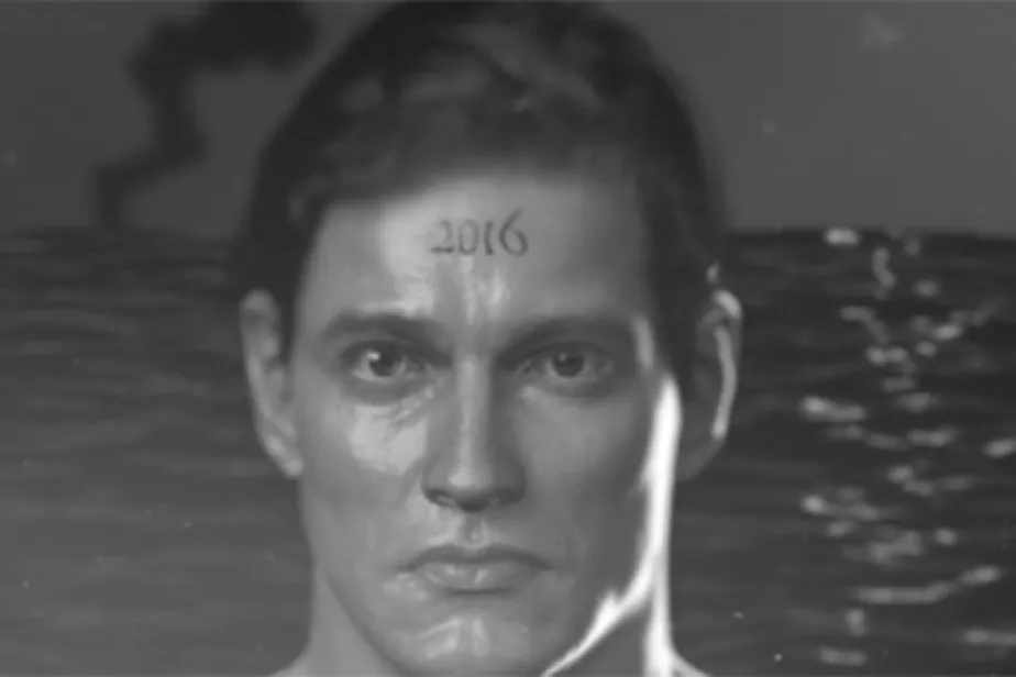 Visage d'un homme à fleur d'eau avec tatouage "2016" sur le front